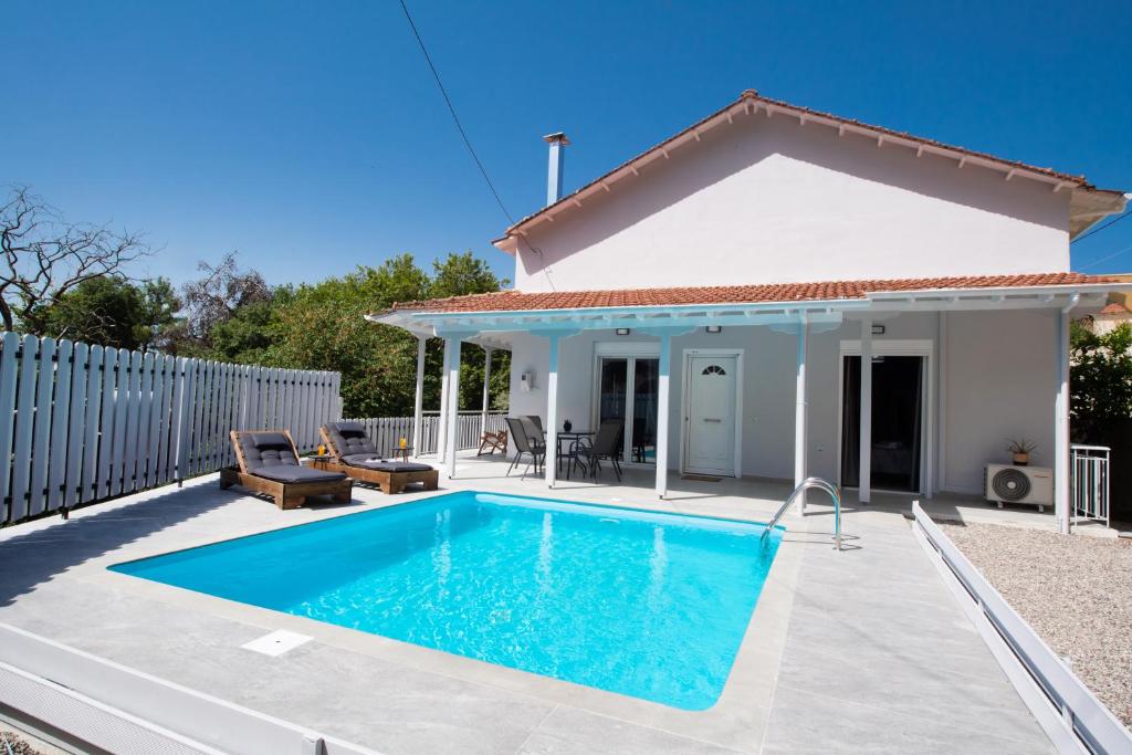 uma villa com piscina em frente a uma casa em Beyond The Bridge em Sívros