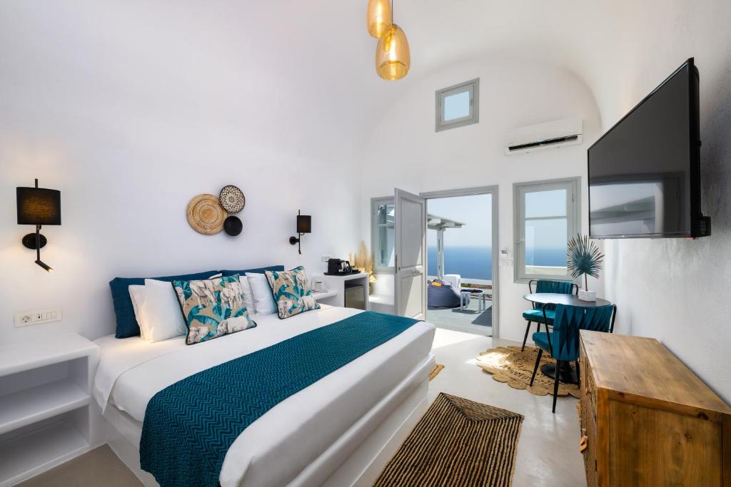 sypialnia z łóżkiem, telewizorem i stołem w obiekcie Siete Mares Luxury Suites w Imerovíglion