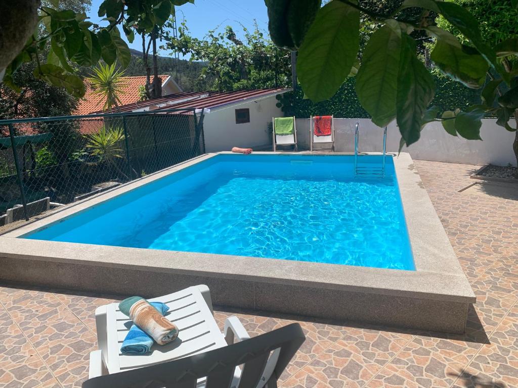 einen Pool mit zwei Stühlen, einem Tisch und einem Stuhl sidx sidx in der Unterkunft Casa do Outeiro in Mondim de Basto