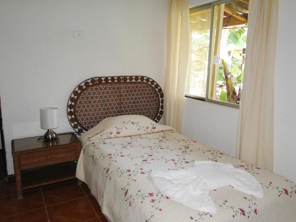 a bedroom with a bed and a window at Tupa Hotel in Hanga Roa