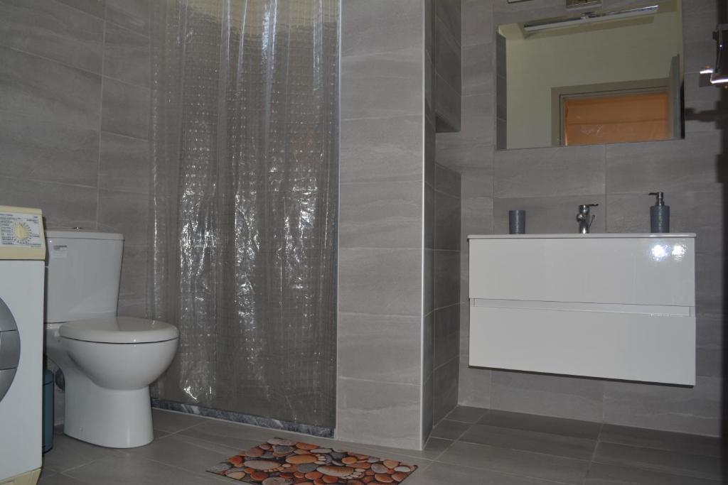łazienka z toaletą, umywalką i prysznicem w obiekcie Garden&Sea studio w Kalamácie