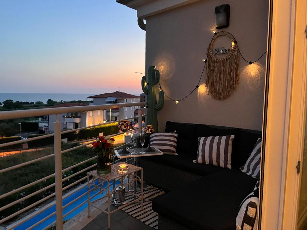 een balkon met een zwarte bank en een tafel bij ZURI-sea wiev in Zambratija
