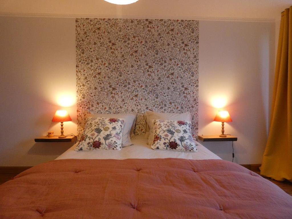 a bedroom with a large bed with two lamps at Chez Elise et Thomas in Le Mage