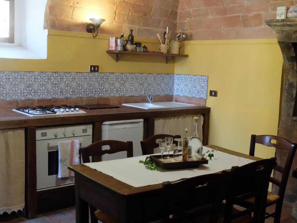 une cuisine avec une table et une cuisine aux murs jaunes dans l'établissement case vacanza da Rosina e T, à Santo Stefano di Sessanio