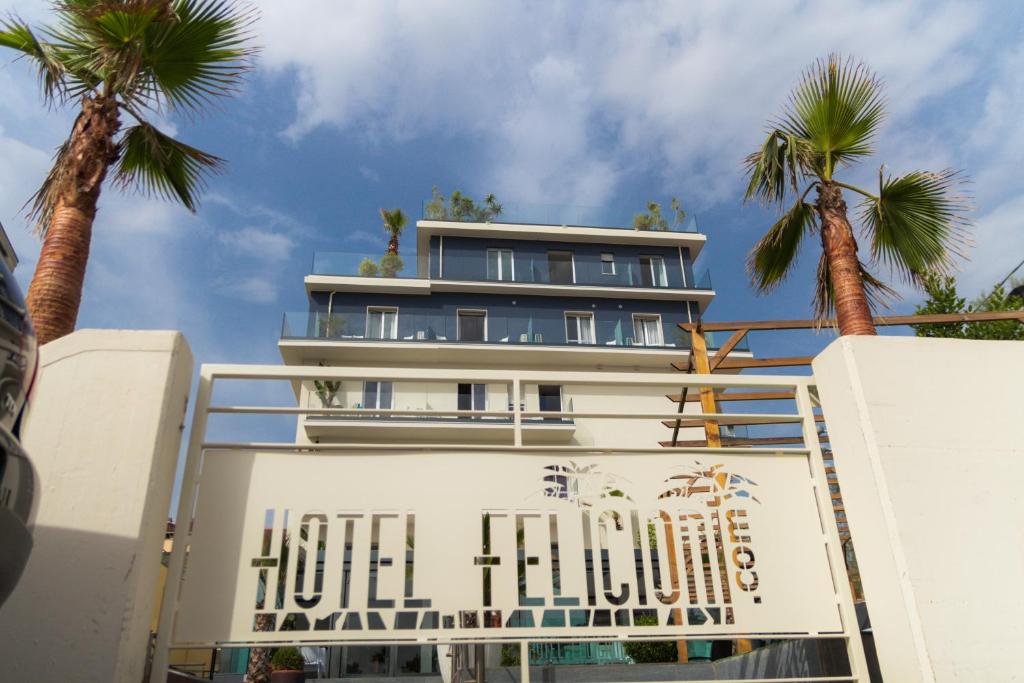 a hotel building with palm trees in front of it at Hotel Felicioni in Pineto