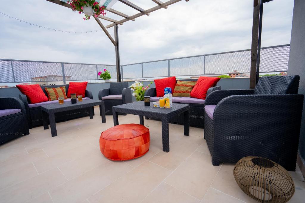 a patio with couches and tables on a roof at Vila 27 in Eforie Nord