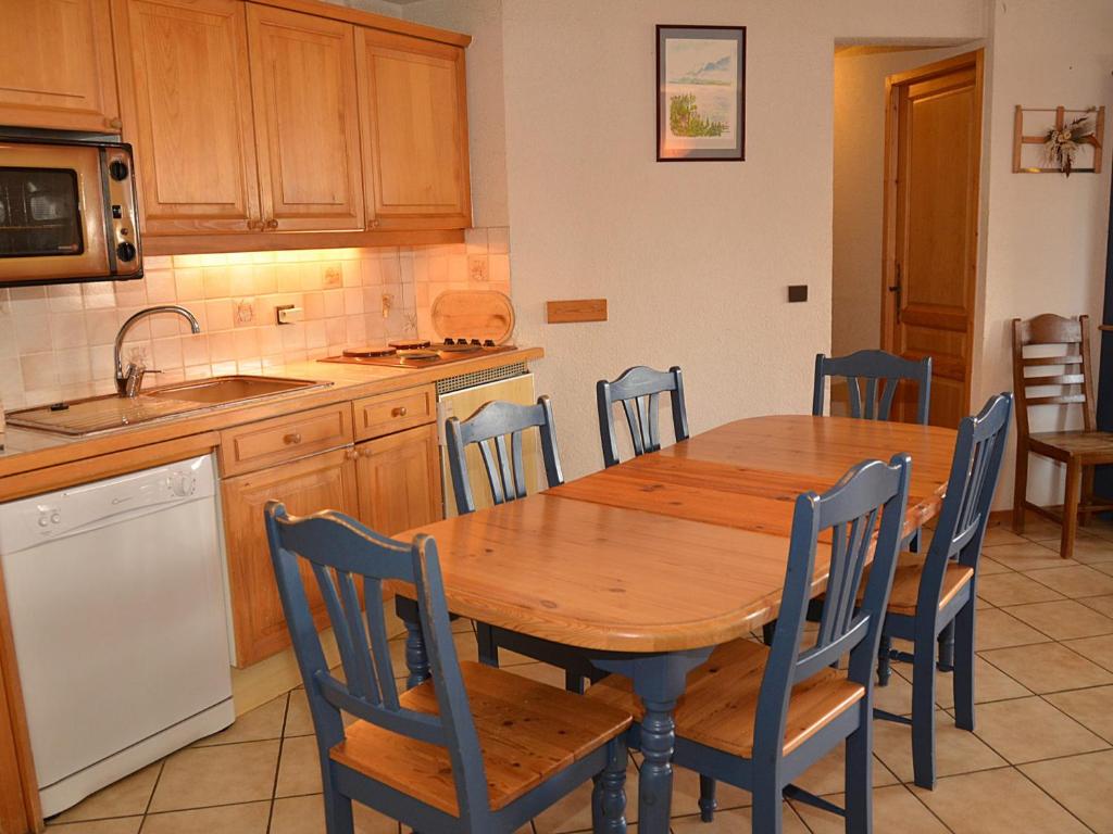 フレーヌにあるAppartement Flaine, 3 pièces, 8 personnes - FR-1-425-2のキッチン(木製テーブル、青い椅子付)