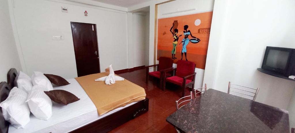 a room with a bed and a table and a television at iSTAYS - Loop Road, Yercaud in Yercaud