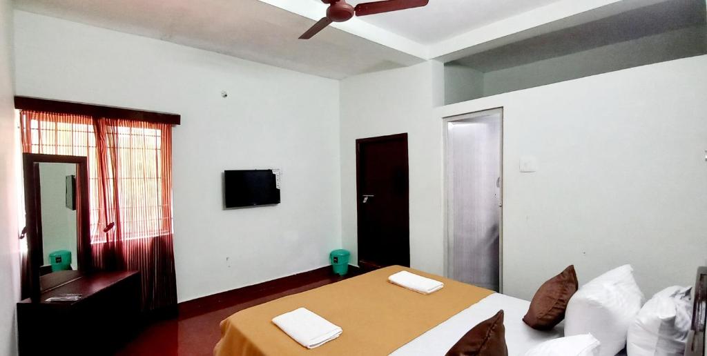 a bedroom with a bed and a ceiling fan at iSTAYS - Loop Road, Yercaud in Yercaud