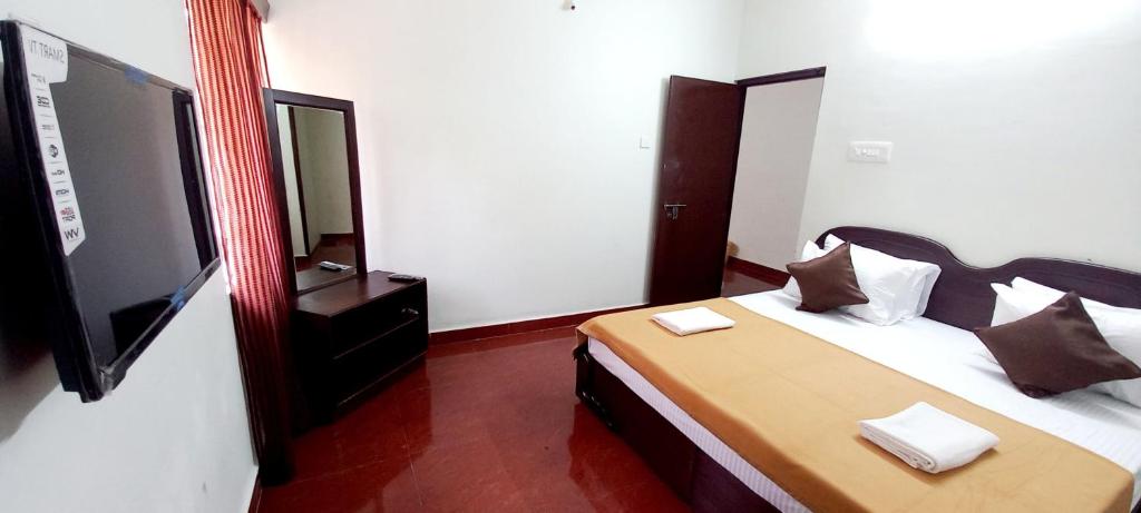 a bedroom with a bed with a mirror and a tv at iSTAYS - Loop Road, Yercaud in Yercaud