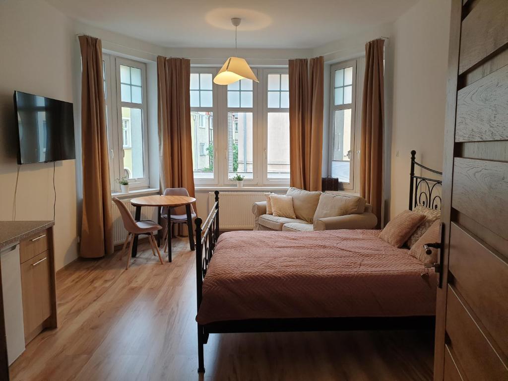 a bedroom with a bed and a living room at Apartamenty Dora in Sopot