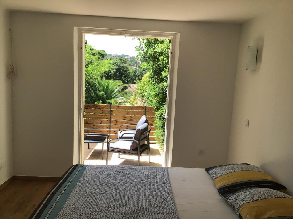 - une chambre avec un lit et une porte donnant sur une terrasse dans l'établissement Escapade côte d'Azur, à Saint-Aygulf