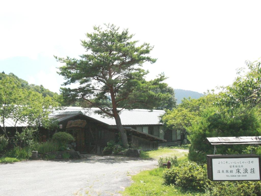 a house with a tree next to a road at Tokonamiso in Nagiso