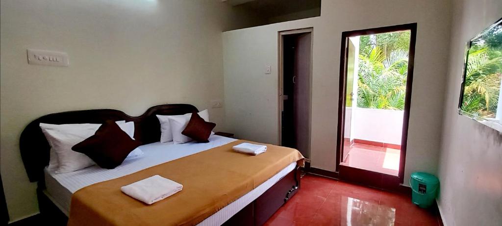 a small bedroom with a bed with a window at iSTAYS - Loop Road, Yercaud in Yercaud