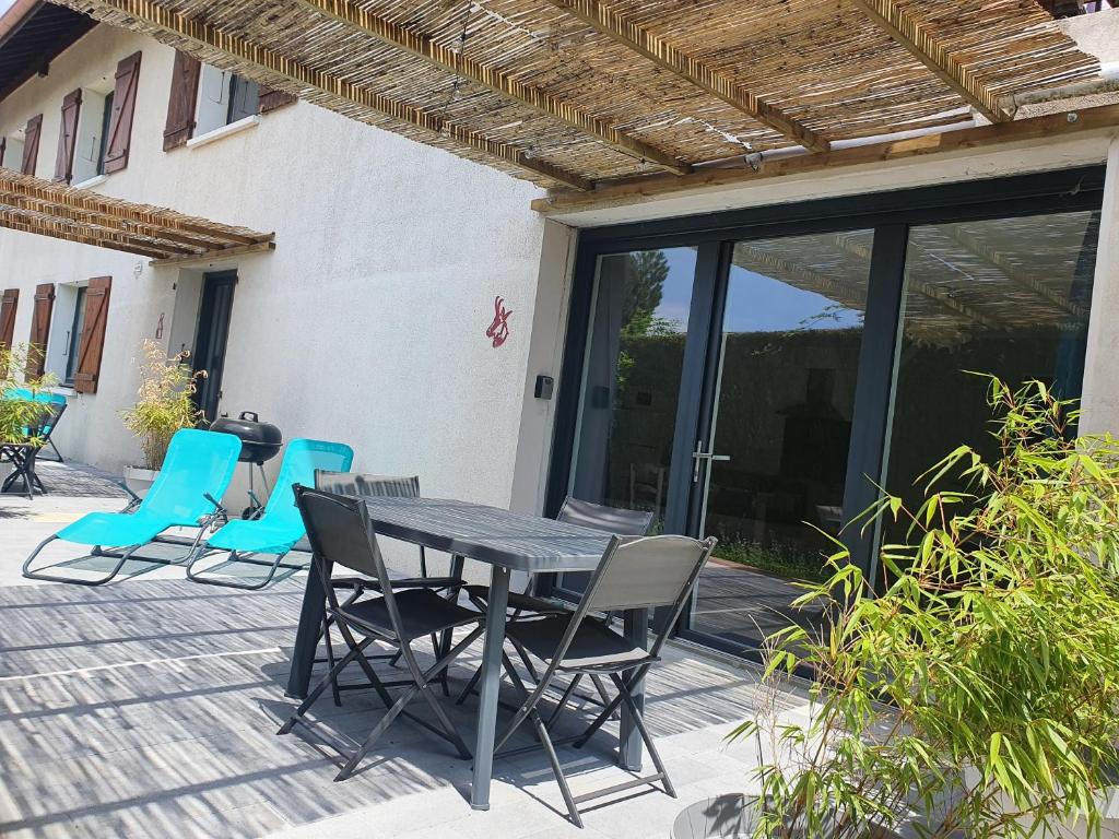 een tafel en stoelen op een patio bij LA PIERRINA - Chamois - Appart 3 étoiles in Aix-les-Bains