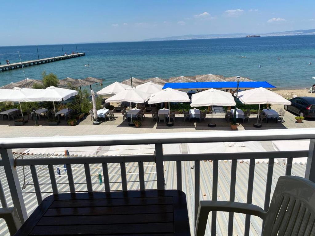 een uitzicht op een strand met tafels en parasols bij Sunset view Rooms in Agia Triada