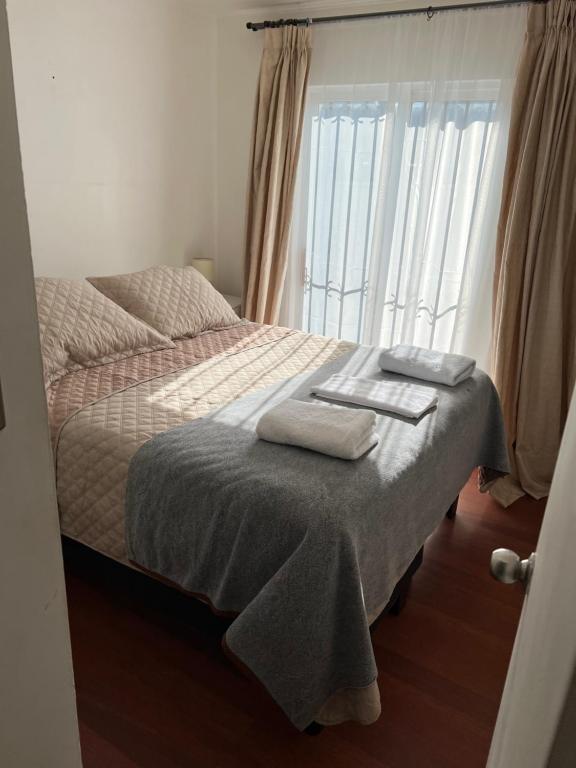a bedroom with a bed with two towels on it at Apart Hotel Chillan - Full House 2 Ohiggins - Empresas - Factura in Chillán