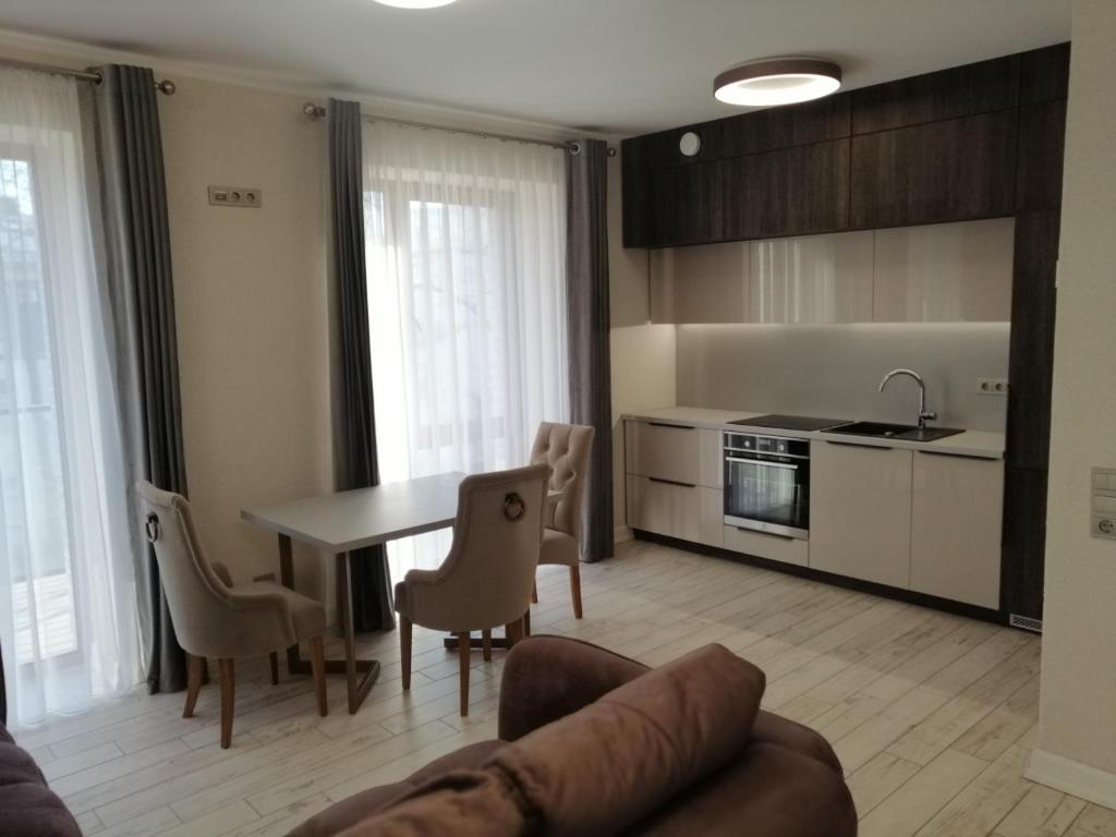 a kitchen and living room with a table and chairs at Savaitė Vilniuje in Vilnius