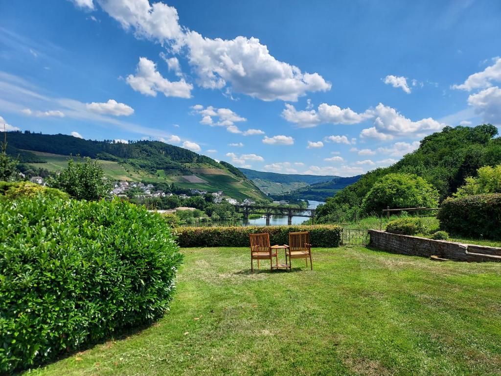 two chairs and a table in the yard of a house at Ferienhaus Prinzenkopf in Alf