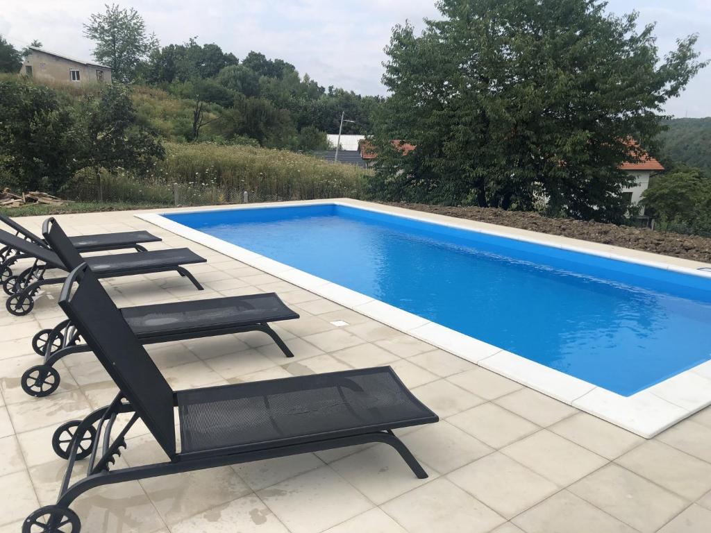 a swimming pool with lounge chairs and a swimming pool at Relax House Banja Luka in Banja Luka