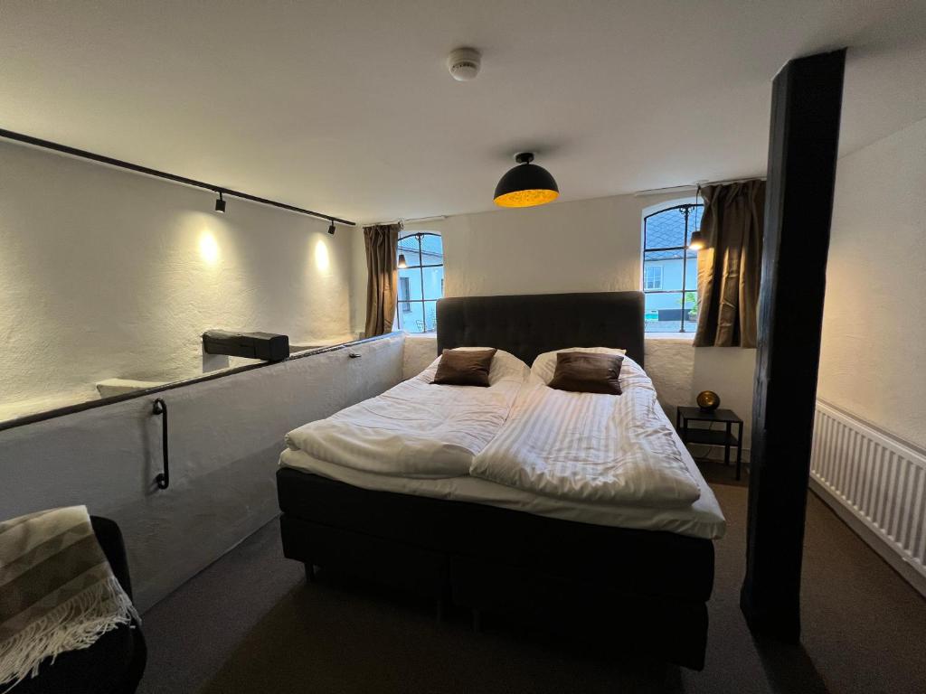 1 dormitorio con 1 cama grande con sábanas y almohadas blancas en Backadal Gård BnB, en Ystad
