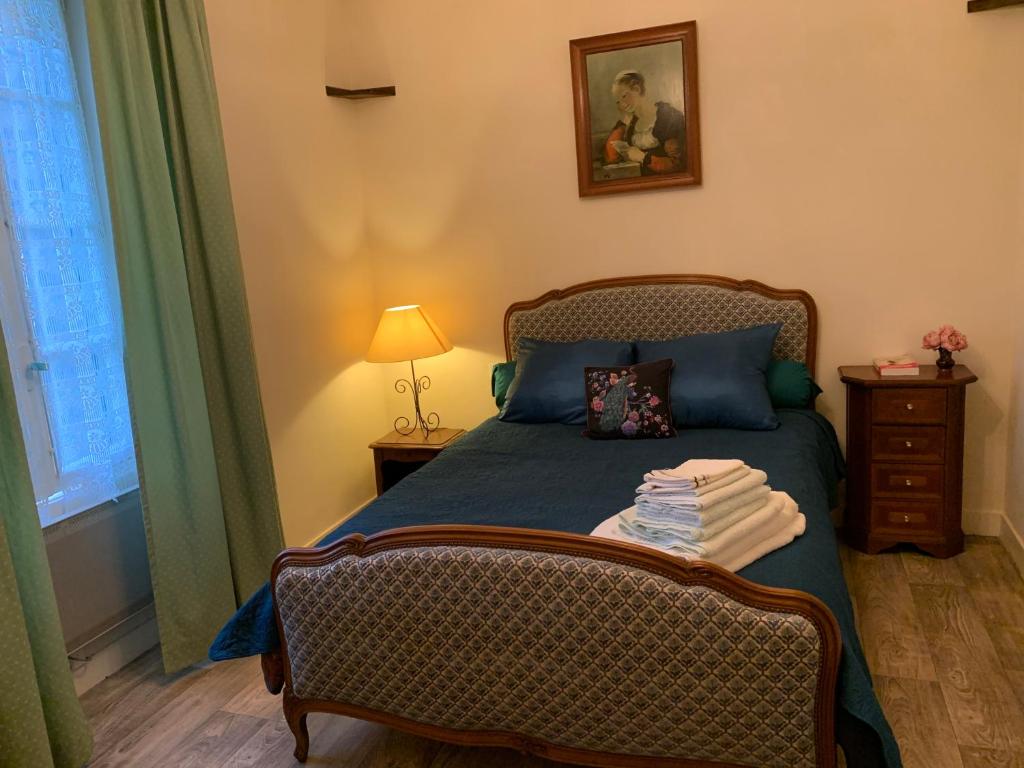 a bedroom with a bed with a blue comforter at Treignac Tourelles in Treignac