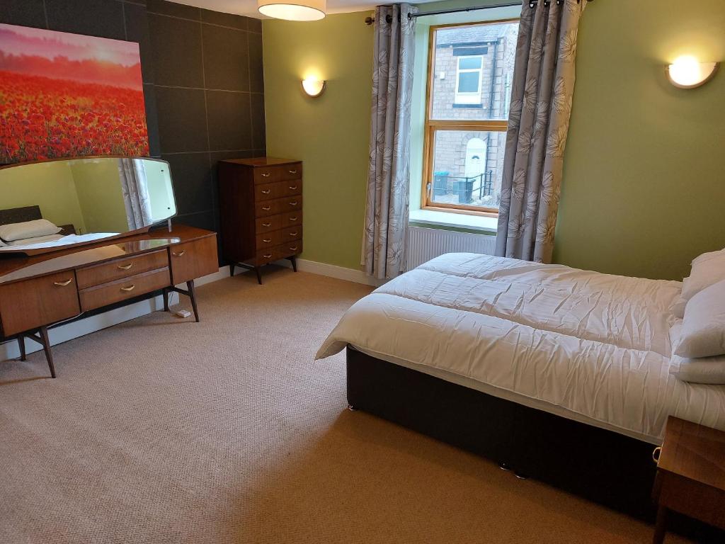 een slaapkamer met een bed, een dressoir en een spiegel bij Apartment above Sweetharts bakery and coffeeshop in Blackhill, Durham in Shotley Bridge
