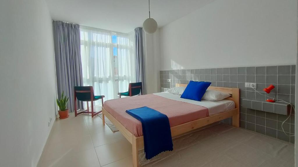 une chambre avec un lit avec des oreillers bleus dans l'établissement A casa da sardiña. Unha parada no Atlántico, à Fisterra