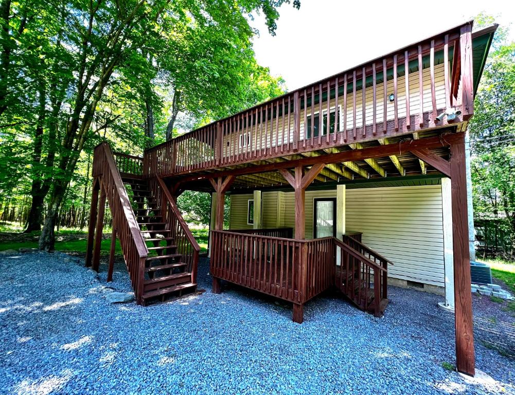 a house with a deck and a staircase in front at Oak circle chalet Pocono gated community - 1 min walk to Deerfield lake in Lake Ariel