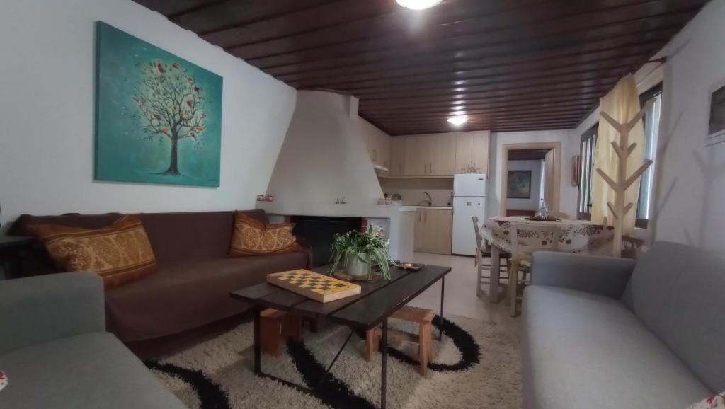 a living room with a couch and a table at VillaTzer - Traditional house with fireplace and garden in Tzermiádon