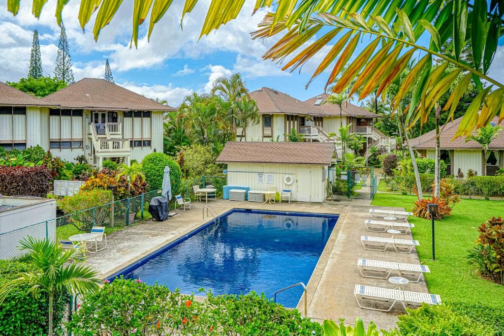 a house with a swimming pool in a yard at Paniolo #202 A & B in Princeville
