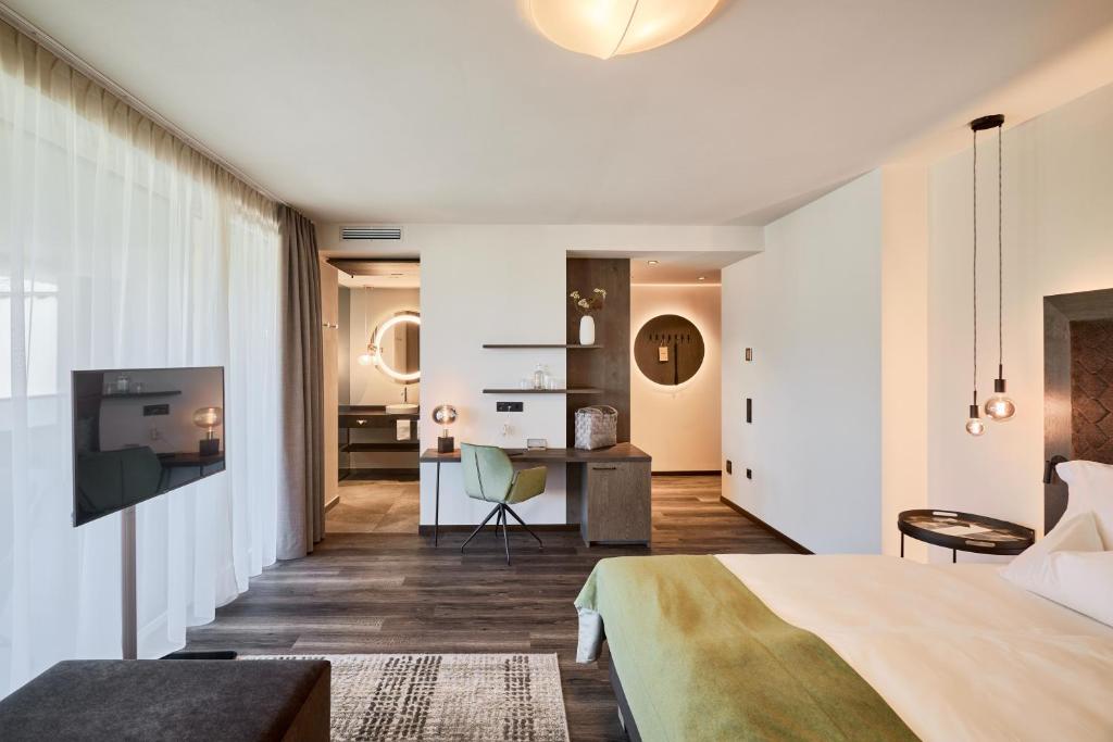 um quarto com uma cama e uma secretária num quarto em Appius Design Suites B&B - ADULTS ONLY em Appiano sulla Strada del Vino