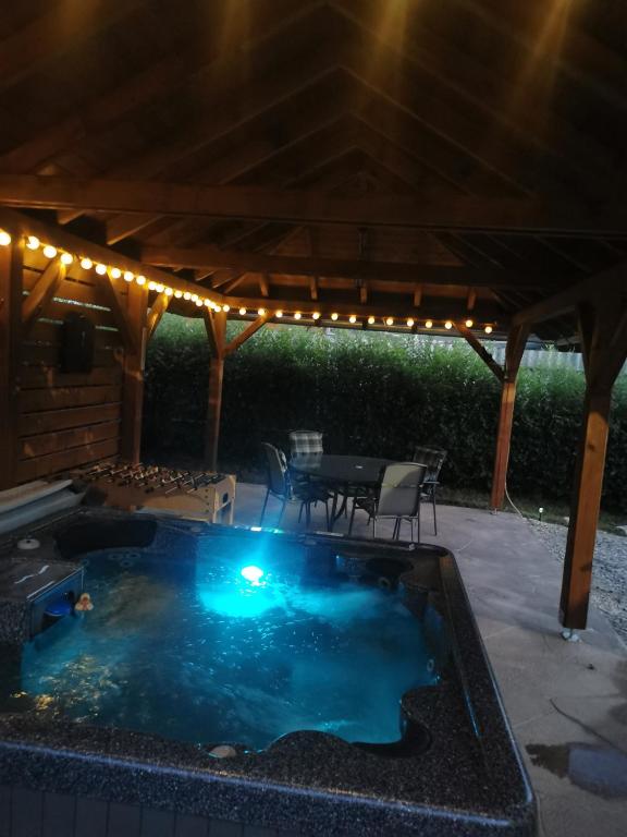 a hot tub in the middle of a patio at night at Zso-Zé Apartman in Tiszafüred
