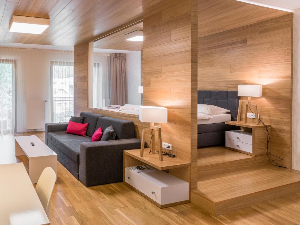 uma sala de estar com um sofá e uma cama em Suites and Apartments Medvědín em Špindlerŭv Mlýn