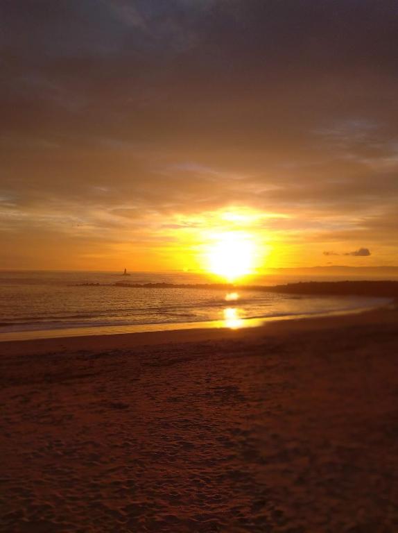 a sunset on the beach with the sun setting at Mesón da Pedra in Burela de Cabo