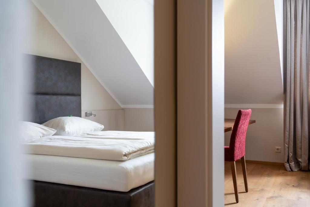 eee Hotel Perg في بيرغ: غرفة نوم مع سرير ومكتب مع كرسي