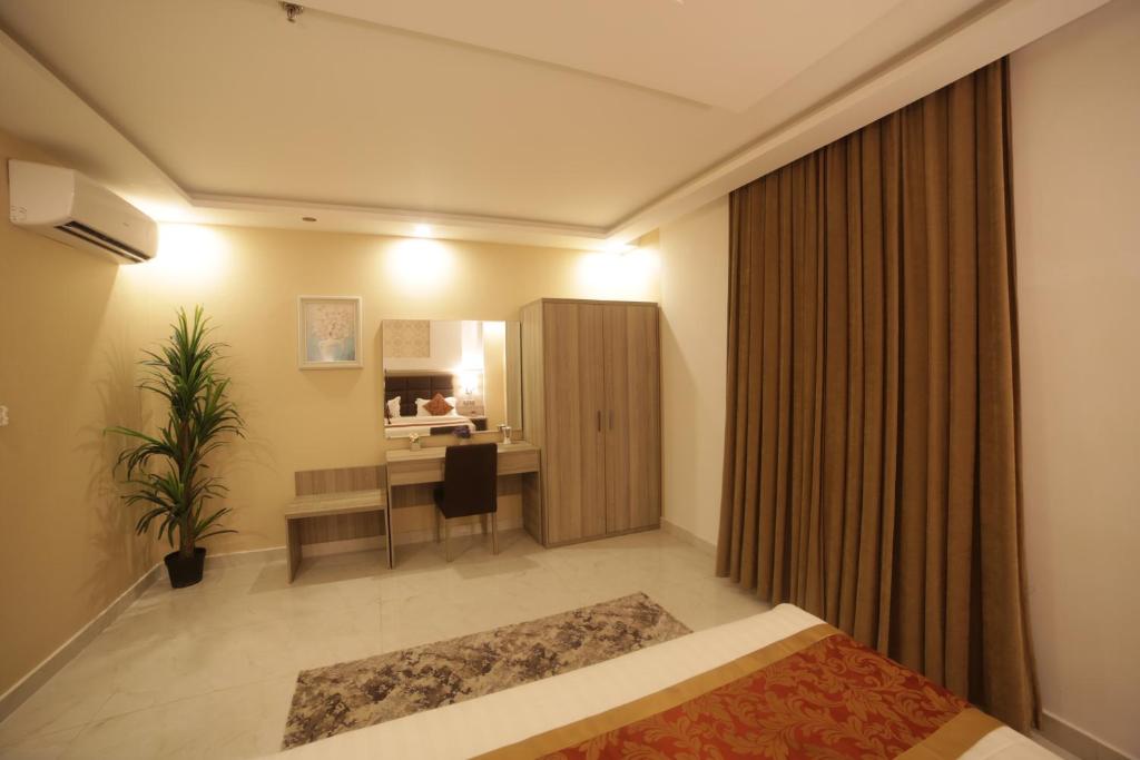 Un pat sau paturi într-o cameră la First Diamond Served Apartments formerly Hekayat Abeer