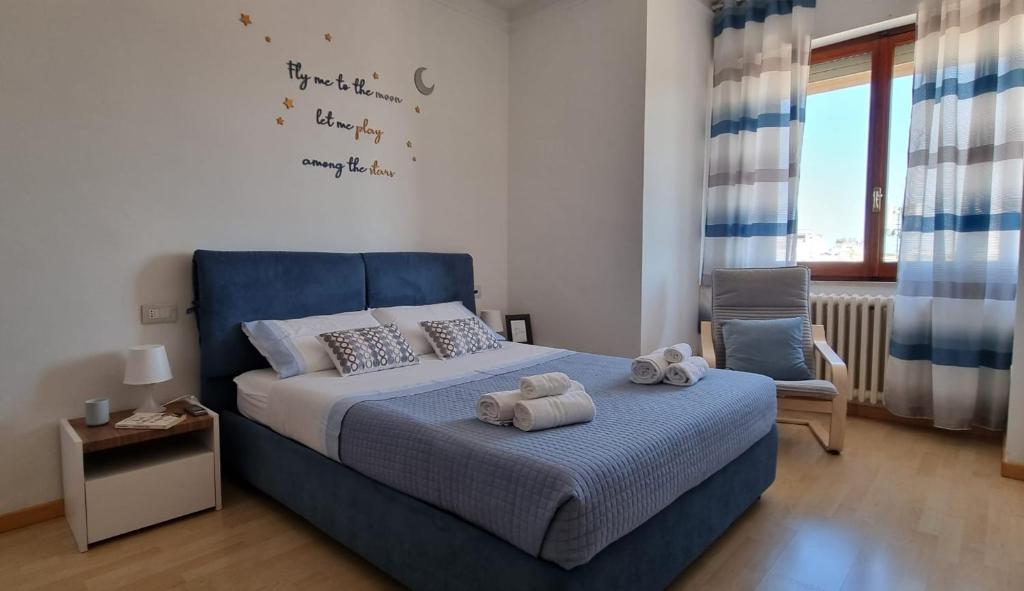a bedroom with a blue bed and a chair at The Playce Apartments in Civitanova Marche