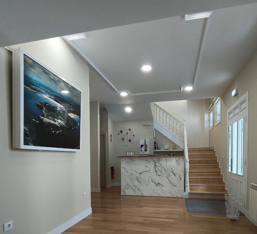 uma sala de estar com uma escada e um quadro na parede em Hotel Posada del Mar em Suances