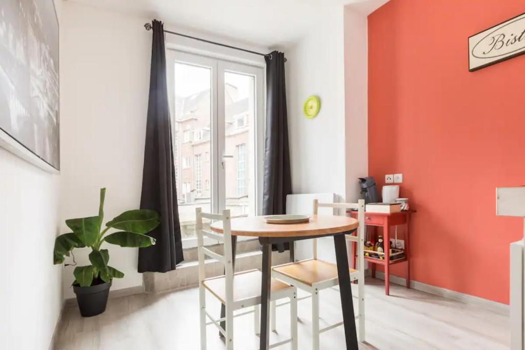 a dining room with a table and chairs and a window at Apt B Boston, 25m2, Centre, Balcon 1 in Valenciennes