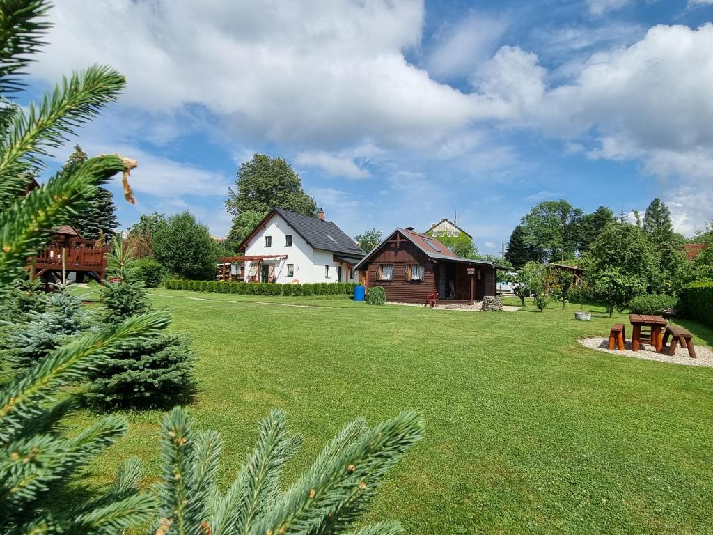 un patio con una casa y un campo de hierba en Dům a chatka pod Smrkem, en Nové Město pod Smrkem
