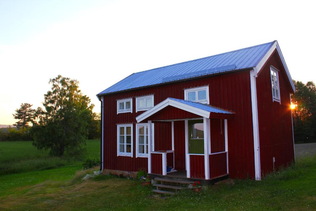 un granero rojo con techo solar en un campo en Lilly's house, Swedish High Coast, en Docksta