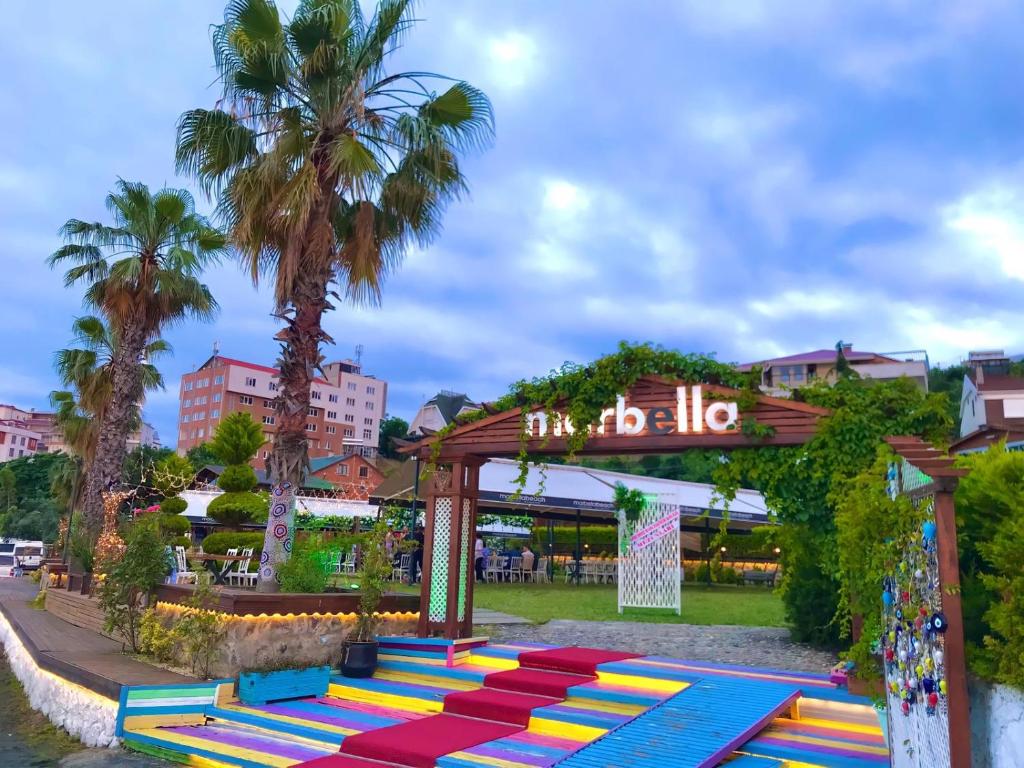 um grupo de bancos coloridos em um parque com palmeiras em Marbella Kale Beach em Akçakale