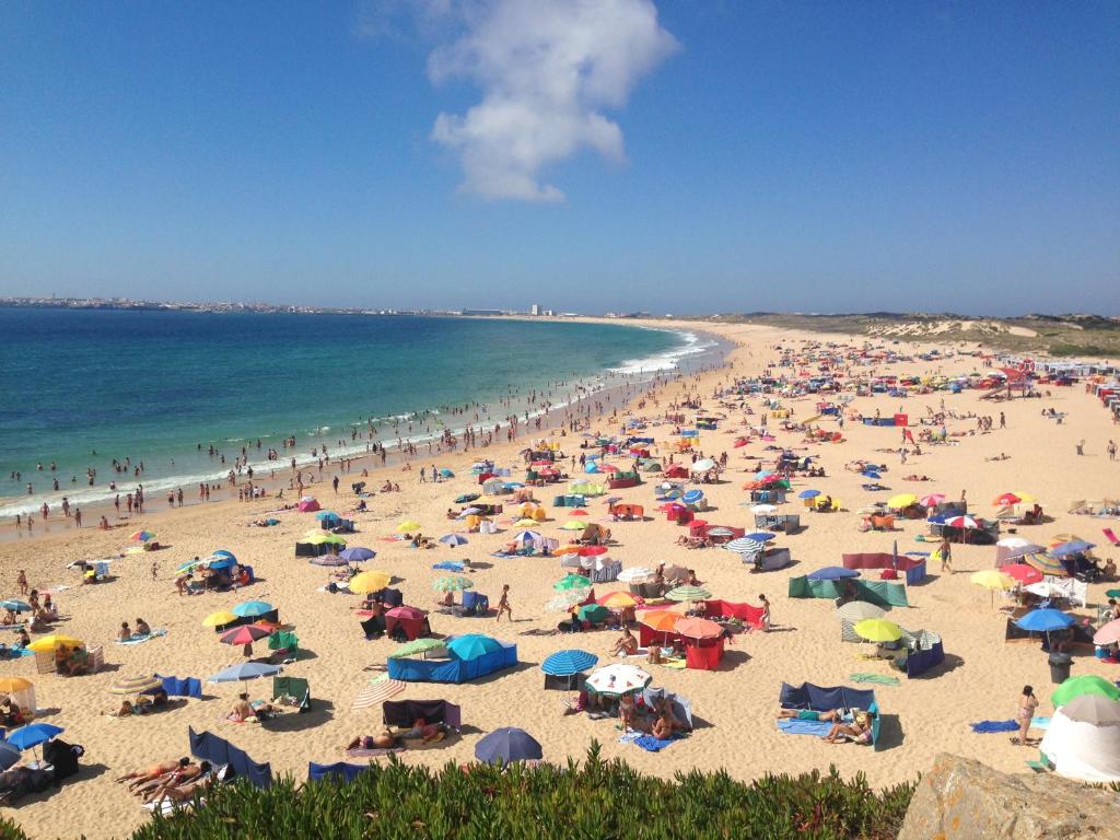 a crowd of people on a beach with umbrellas at Brisa Do Mar - Consolação in Peniche