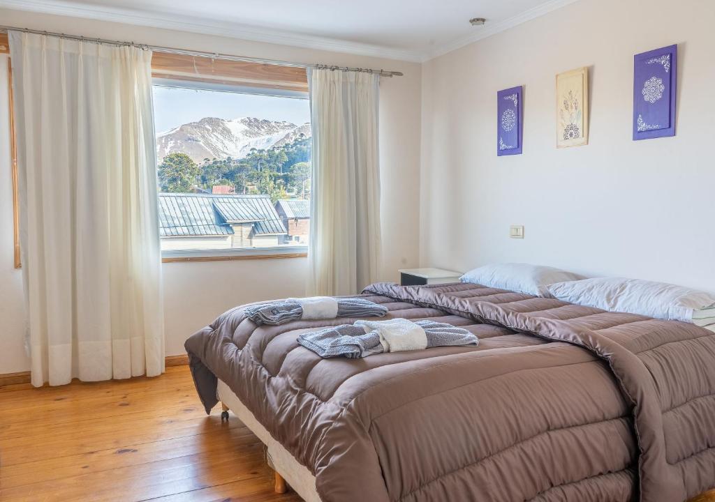 1 dormitorio con 2 camas y ventana grande en Hotel Nuke Piren en Caviahue