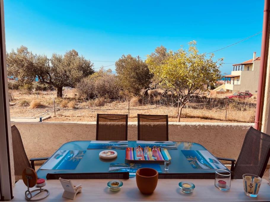 a blue table with chairs and a view of a field at A View Home _ Agkistri in Megalochori