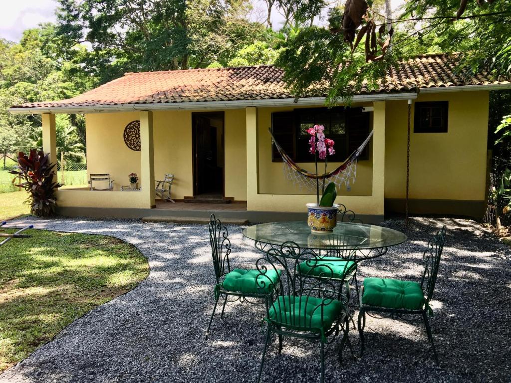 Recanto da Floresta - Casa de campo em Secretário في بتروبوليس: طاولة وكراسي أمام المنزل