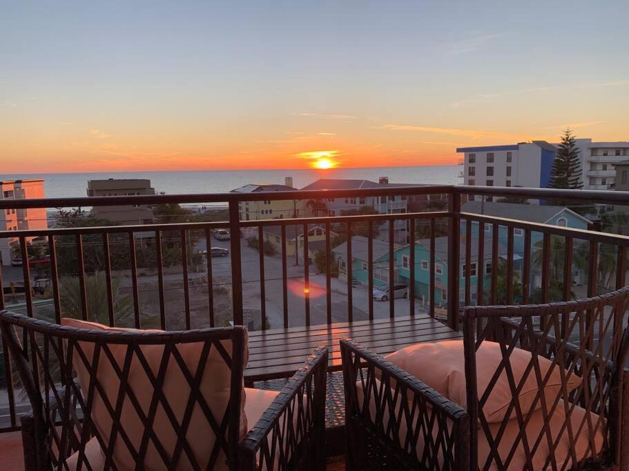 uma vista para o pôr-do-sol a partir de uma varanda em Two Bedroom Condo With Views Of The Beach & Gulf em St. Pete Beach