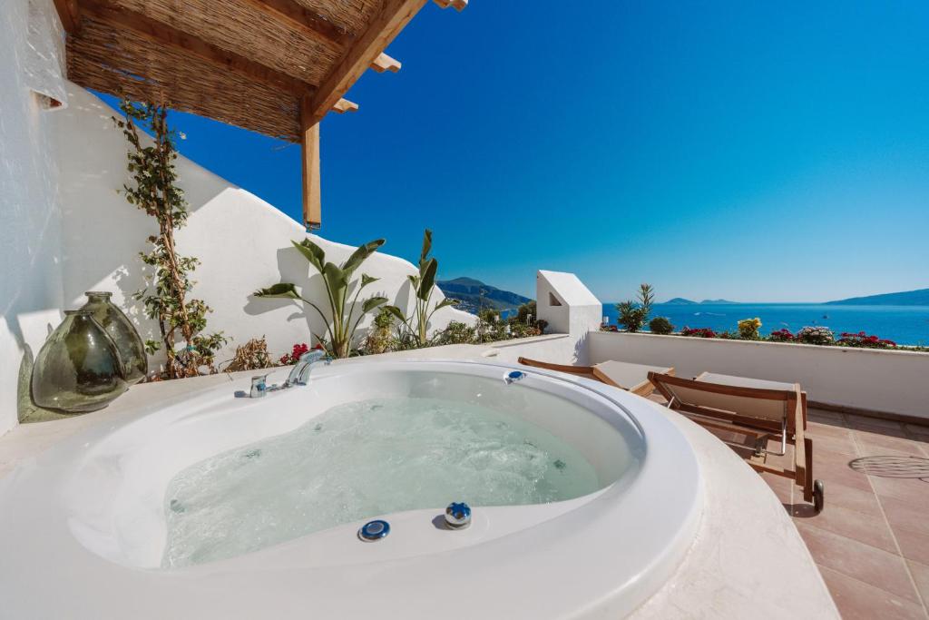 a bath tub in a room with a view of the ocean at Kalkan Han Hotel in Kalkan