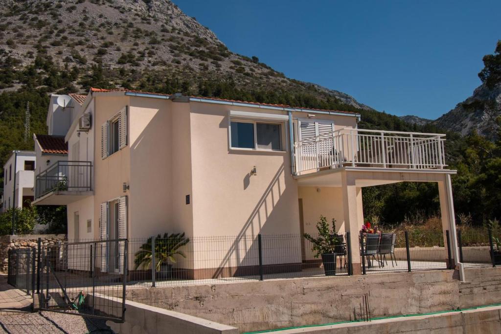 une maison avec un balcon et une montagne dans l'établissement Kuća za odmor MIRIS BORA, à Orebić
